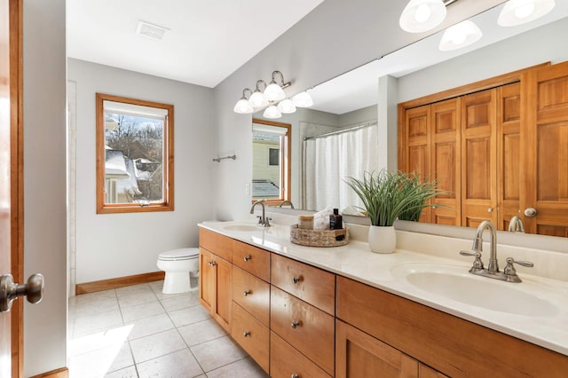 full bathroom with toilet, baseboards, a sink, and tile patterned floors