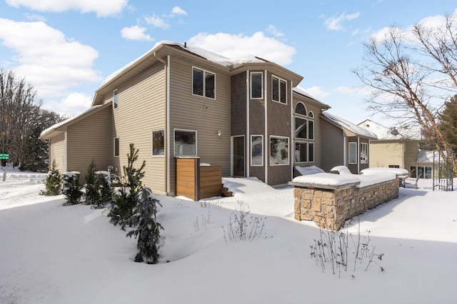 view of snow covered back of property