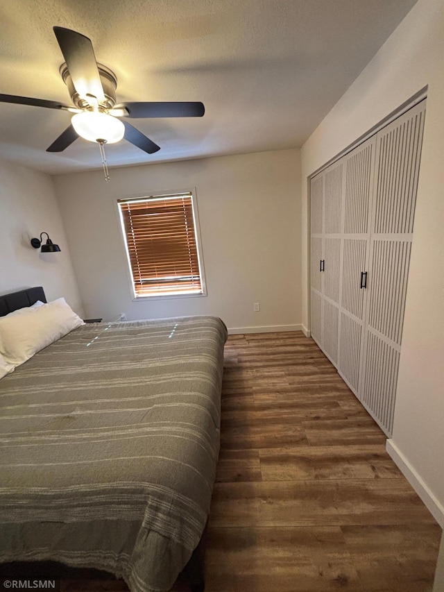 bedroom featuring ceiling fan, a textured ceiling, wood finished floors, and baseboards