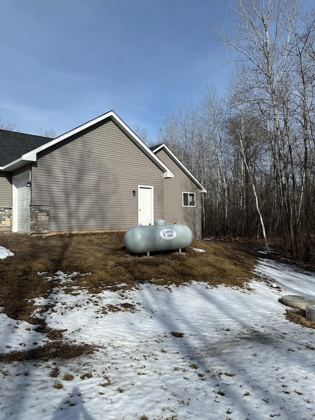 snow covered property featuring an attached garage