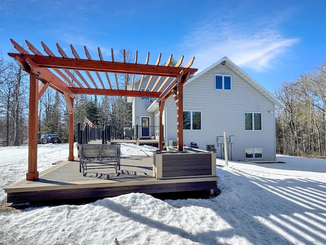 snow covered property with a deck and a pergola