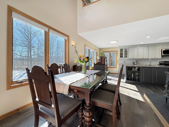 dining room featuring recessed lighting, a healthy amount of sunlight, dark wood finished floors, and baseboards