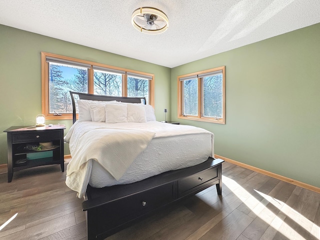 bedroom featuring baseboards, a textured ceiling, and hardwood / wood-style floors