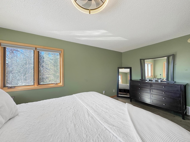 bedroom featuring visible vents, a textured ceiling, and wood finished floors