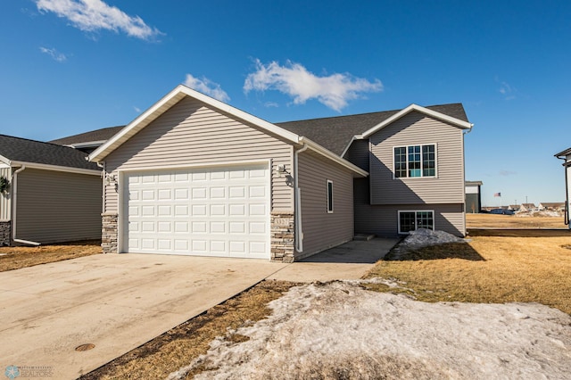 view of front of property with a garage, stone siding, and concrete driveway