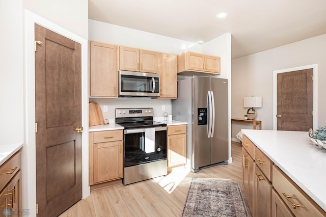 kitchen featuring stainless steel appliances, light wood-type flooring, light countertops, and light brown cabinets