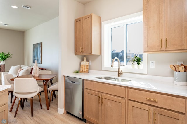 kitchen featuring dishwasher, light wood-style flooring, light countertops, light brown cabinets, and a sink