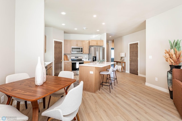 kitchen featuring light wood-style flooring, a kitchen island, stainless steel appliances, light brown cabinetry, and recessed lighting