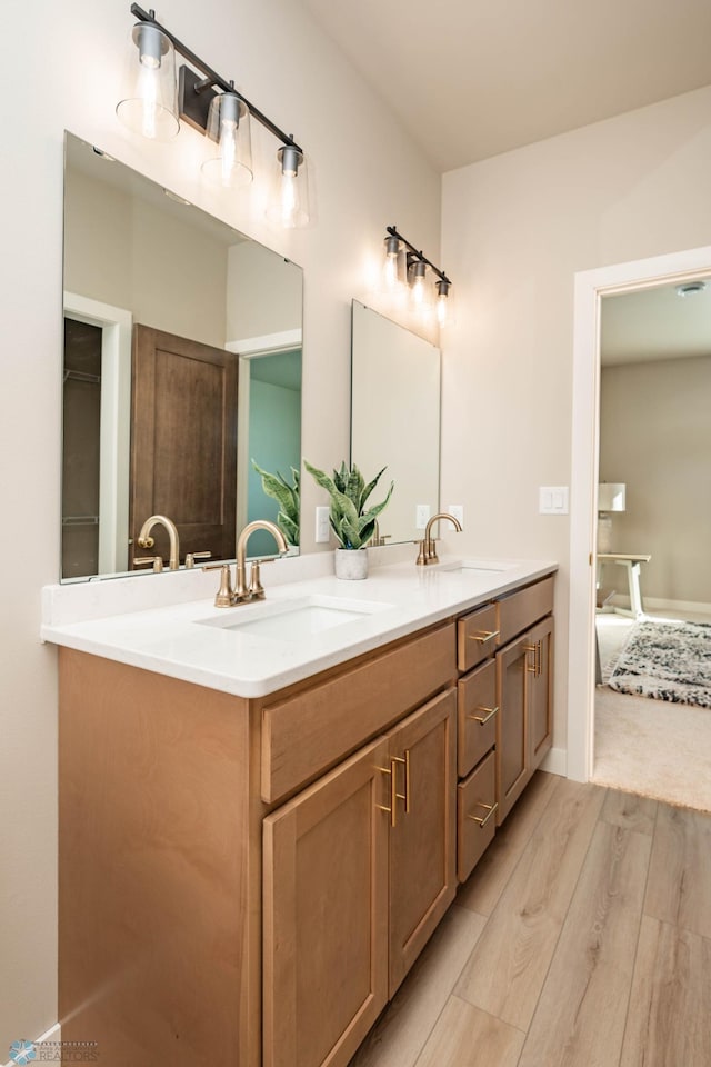 bathroom featuring double vanity, a sink, and wood finished floors