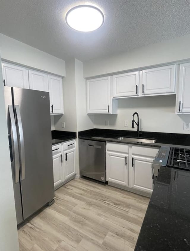 kitchen featuring white cabinets, appliances with stainless steel finishes, and a sink