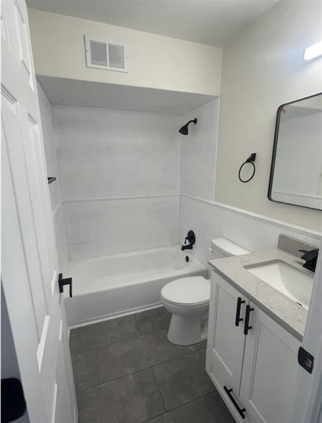 full bathroom featuring visible vents, toilet, shower / bathing tub combination, wainscoting, and vanity