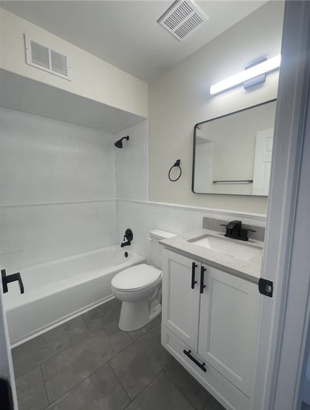 bathroom featuring visible vents, toilet, tub / shower combination, and tile walls