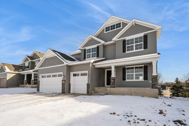 craftsman-style house with a garage, stone siding, and covered porch