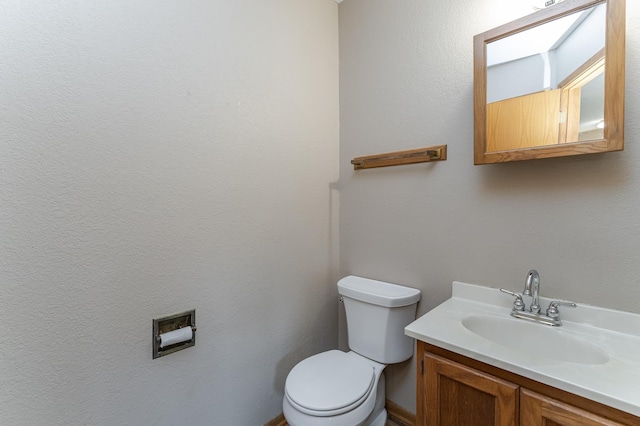 half bathroom with toilet and vanity