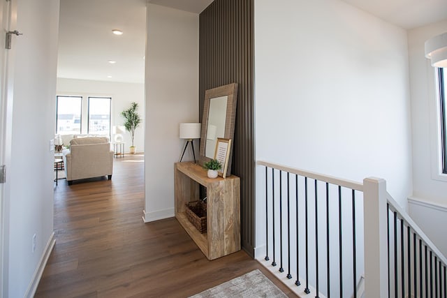 hall featuring recessed lighting, baseboards, an upstairs landing, and dark wood-style flooring