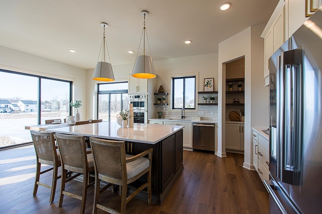 kitchen with open shelves, light countertops, appliances with stainless steel finishes, white cabinetry, and a sink