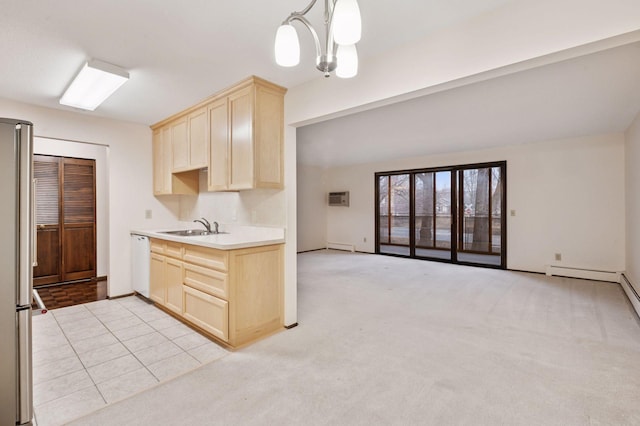 kitchen with a sink, high quality fridge, white dishwasher, and light brown cabinets