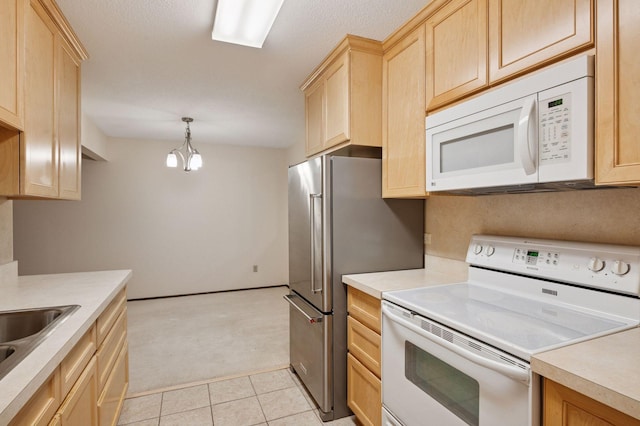 kitchen with light brown cabinets, light carpet, white appliances, a sink, and light countertops