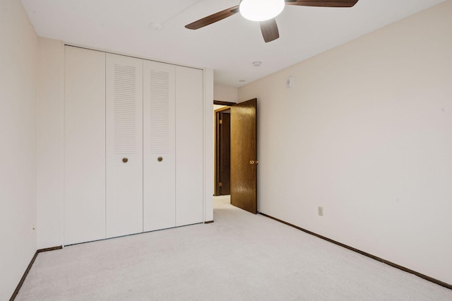 unfurnished bedroom with baseboards, a closet, a ceiling fan, and light colored carpet