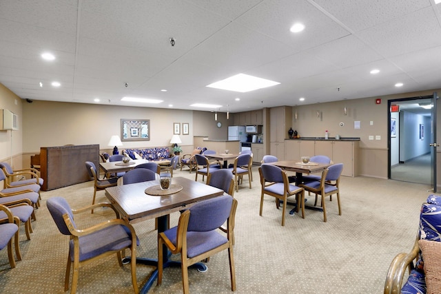 dining room with a paneled ceiling, recessed lighting, and light colored carpet