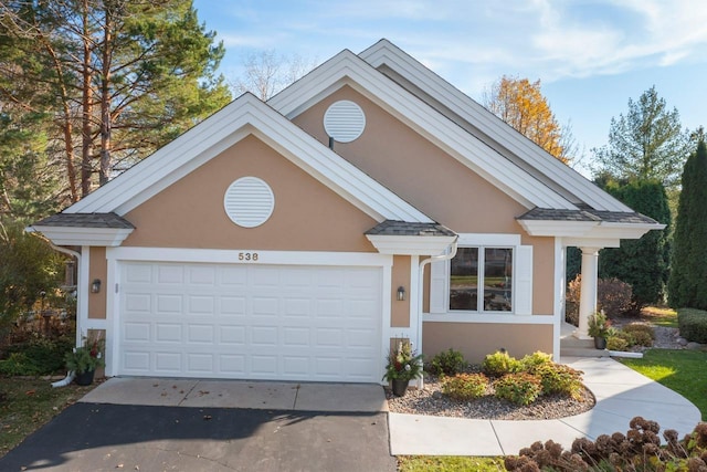 view of front of house with driveway, a garage, and stucco siding