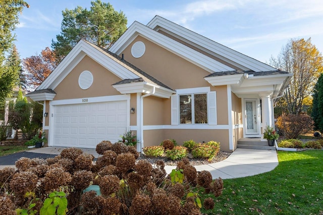 view of front facade featuring a garage, driveway, and stucco siding