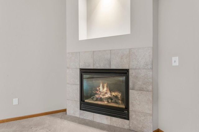 interior details featuring carpet, a tile fireplace, and baseboards