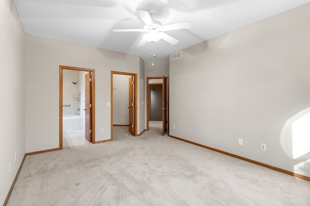 unfurnished bedroom with baseboards, visible vents, ensuite bath, a spacious closet, and carpet flooring