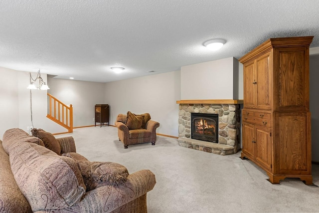 living area with light carpet, stairway, a textured ceiling, and a stone fireplace