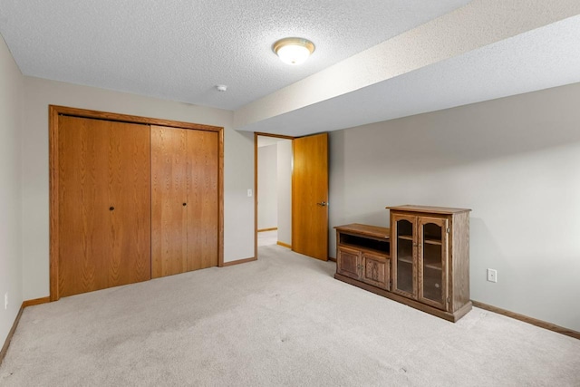 unfurnished bedroom featuring a textured ceiling, baseboards, a closet, and carpet flooring