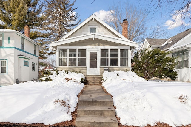 bungalow featuring a chimney and a sunroom