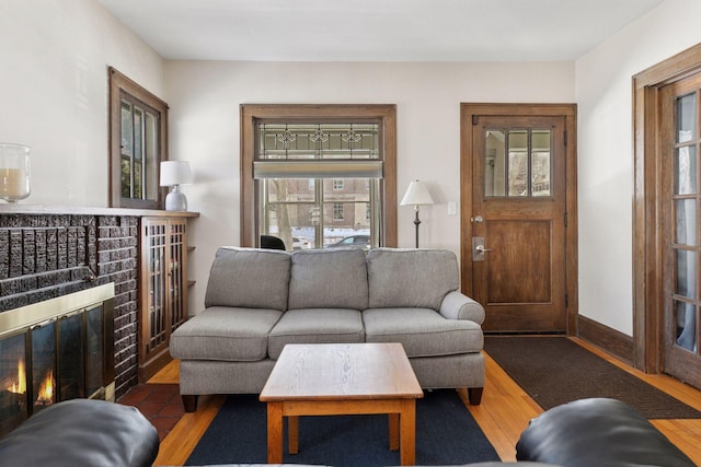 living room with a wealth of natural light, baseboards, and wood finished floors