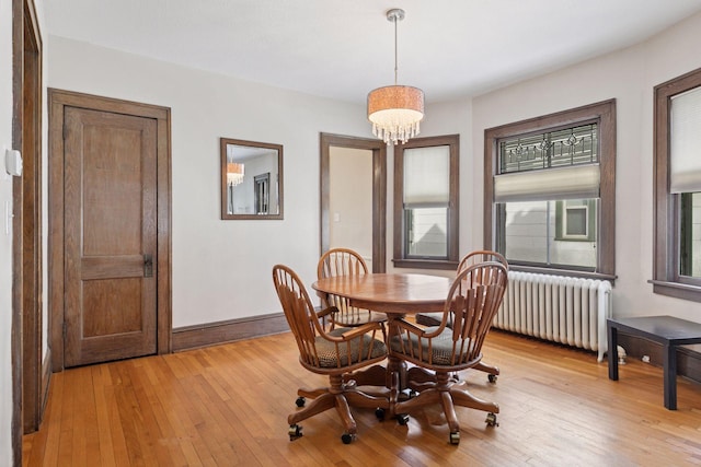 dining space featuring a chandelier, radiator, light wood-type flooring, and baseboards