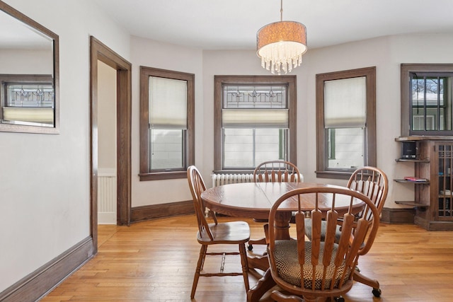 dining space featuring plenty of natural light, light wood-style flooring, baseboards, and an inviting chandelier