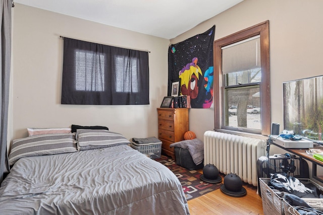 bedroom featuring radiator and wood finished floors