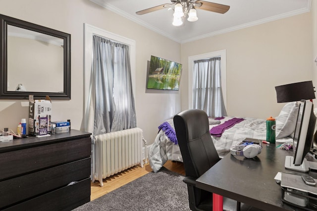 bedroom with light wood finished floors, radiator, a ceiling fan, and ornamental molding