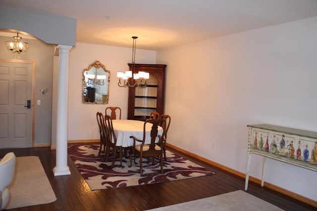 dining space with wood-type flooring, arched walkways, baseboards, a chandelier, and ornate columns