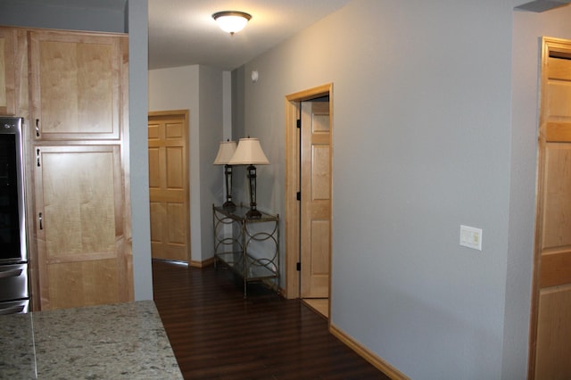 hall featuring dark wood-style floors and baseboards