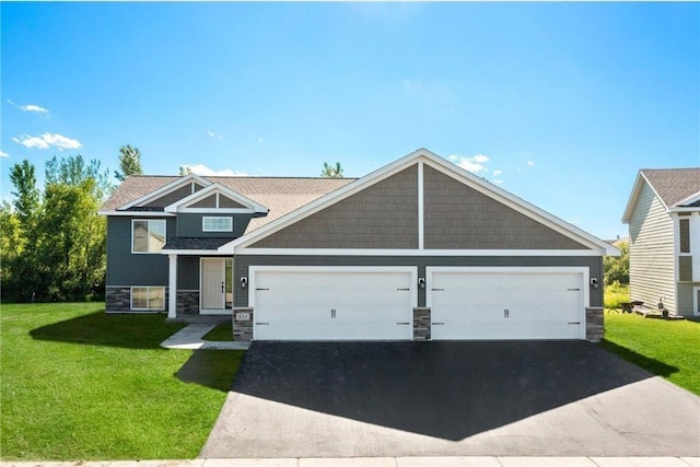 view of front of home featuring an attached garage, stone siding, aphalt driveway, and a front yard