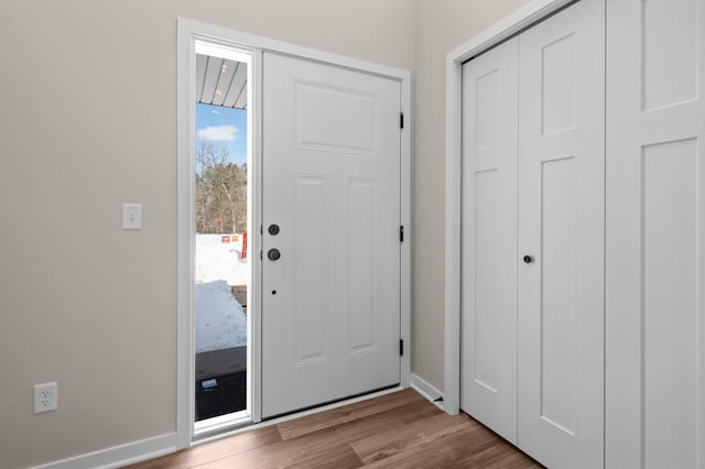 foyer entrance with wood finished floors and baseboards