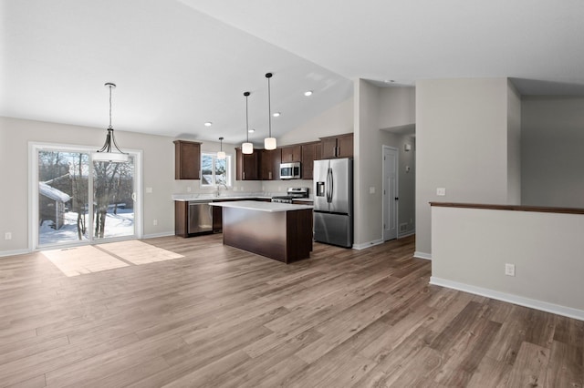 kitchen with open floor plan, light countertops, appliances with stainless steel finishes, and a kitchen island