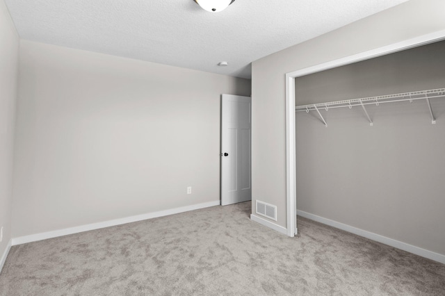unfurnished bedroom with a closet, baseboards, visible vents, and carpet floors