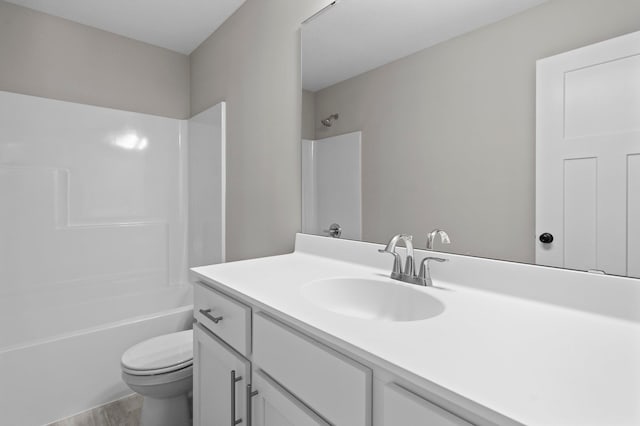 bathroom featuring toilet, shower / bath combination, wood finished floors, and vanity