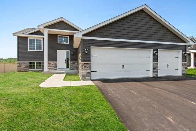 1001 Misty Meadow Blvd, Buffalo, MN 55313 - view of front of house with stone siding, a garage, driveway, and a front lawn