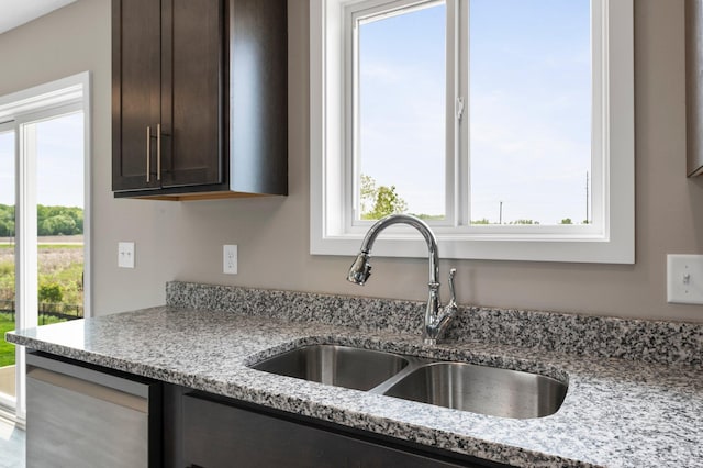 1001 Misty Meadow Blvd, Buffalo, MN 55313 - kitchen featuring a sink, dark brown cabinetry, healthy amount of natural light, and light stone countertops