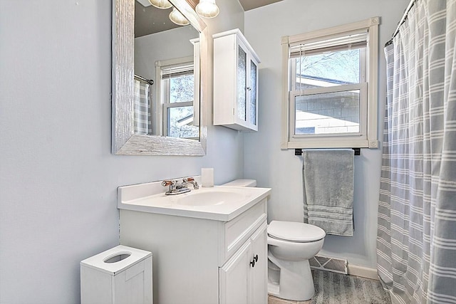 bathroom featuring vanity, toilet, and visible vents