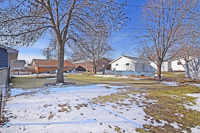 yard layered in snow with a residential view and fence