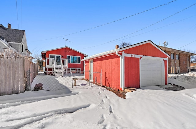 exterior space with an outdoor structure, a garage, and fence