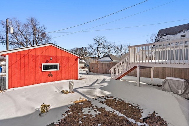 yard layered in snow with a deck, stairway, and fence