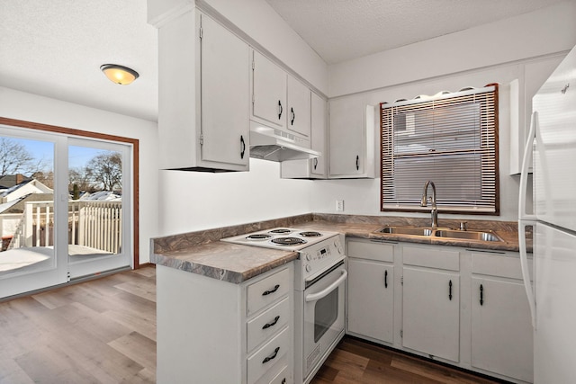 kitchen featuring white appliances, dark wood-style flooring, a sink, under cabinet range hood, and a textured ceiling